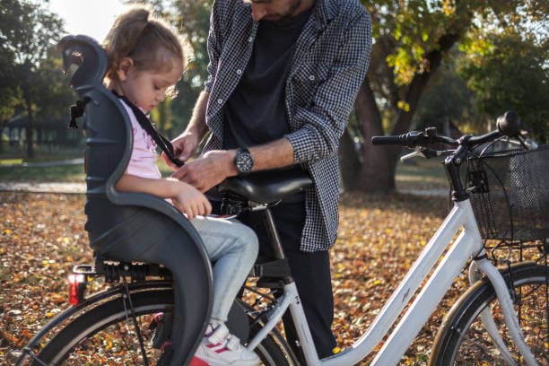 elsykkel med barnesete: barn fastspent i setet