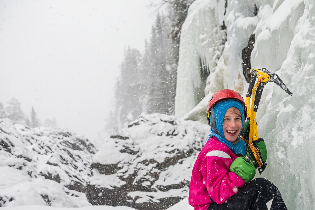 hvordan velge isøks: en gutt klatrer opp en isbre med isøkser